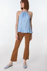 Musculosa color beige de lino, con cuello halter con volados y volados en el ruedo.