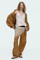 Pantalón de cuero color camel, de tiro alto, corte recto y bolsillos delanteros y traseros.