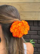 Pinza para el pelo con flores rojas de tela.