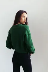 Sweater rosa de punto con detalles de flecos en los laterales y cuello V.