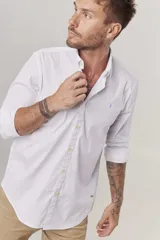 Camisa de hombre color crema, de corte clásico, con cuello abotonado y mangas largas.