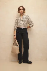 Blusa de manga larga con cuello mao, presenta estampado de lunares y botones a tono.
