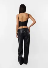 Corset negro de breteles finos y copas preformadas, con cierre frontal de ganchos y ballenas.