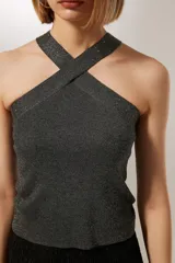 Top cropped gris metalizado con cuello halter y detalle de studs.