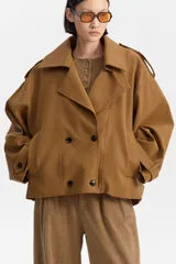 Chaqueta corta estilo sobretodo, color marrón, con silueta amplia, cuello solapa ancho, cierre cruzado con botones oscuros y hombreras.
