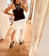 Falda corta de lurex aperlado con flecos y detalles de crochet.