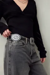 Cinturón negro de símil cuero con diseño western, apliques metálicos circulares y hebilla cuadrada grabada.