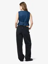 Chaleco de jean azul con cuello en V, cierre frontal con botones metálicos, bolsillos delanteros y corte a la cintura.