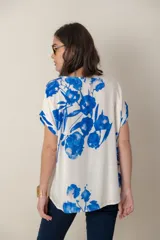 Blusa italiana de calce holgado, talle único, con cuello redondo y mangas cortas. Estampado de flores sobre fondo natural.