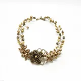 Collar dorado con diseño floral, elaborado con cuentas de diferentes tamaños y tonos de dorado.
