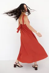 Vestido largo de tirantes color azul con estampado floral blanco en el lateral inferior.