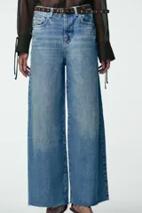Pantalón de jean celeste de tiro alto, corte wide leg cropped, con cinco bolsillos y cinturón marrón con tachas.