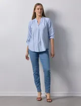 Blusa beige con rayas verticales blancas, escote en V y mangas 3/4 regulables con presilla y botón.