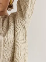 Saco de lana en color beige, con diseño de puntos y cuello de base, ideal para ser una prenda de abrigo elegante.