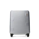 Valija rígida de color negro con diseño de líneas horizontales en relieve y cuatro ruedas dobles.