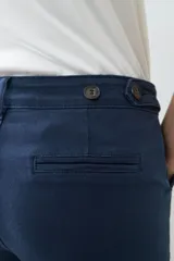 Pantalón chino azul marino con corte recto, bolsillos laterales y traseros, y dobladillo en el tobillo.