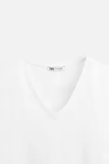 Camiseta negra de algodón con elasticidad, corte slim fit, cuello en V y mangas cortas.