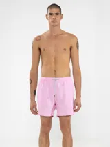 Short de baño rosado con estampado de lunares blancos, cintura elástica con cordón ajustable, bolsillos laterales y trasero con cierre, y suspensor de malla fina hipoalergénica.