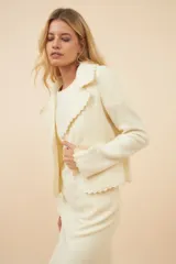 Chaqueta color crudo de lana fina sin teñir, de corte recto con cuello solapa y mangas 3/4.