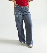 Pantalón de jean azul de tiro bajo, corte wide leg y detalles rotos.