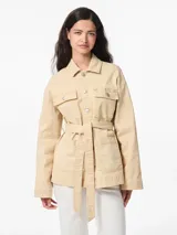 Chaqueta de algodón color arena, con cuello extendido, cierre con botones y cinturón para atar en la cintura.