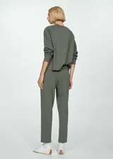 Pantalón negro de piqué con cintura elástica, tiro alto, diseño jogger, bolsillos laterales y costuras decorativas.