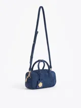 Baulito Lucky de cuero descarne vacuno color azul, con gofrado JCH en la tapa delantera. Incluye correa larga desmontable y regulable. Lleva un charm Lady Bag en el tag.