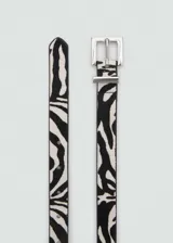 Cinturón de cuero con estampado animal print de cebra, hebilla cuadrada metálica plateada y forro de poliuretano negro.