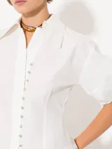 Camisa negra de popelina, de silueta amplia y diseño liviano. Incluye cuello clásico y cierre frontal con botones.