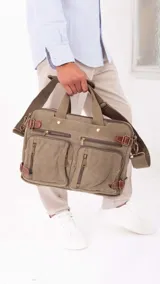 Mochila de tela canvas color beige con detalles en cuero marrón. Cuenta con múltiples bolsillos con cierre, compartimento acolchado para notebook y correas ajustables.