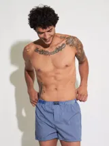 Bóxer de algodón blanco con estampado de flores pequeñas color celeste, con cintura elástica y logo de la marca en el centro.