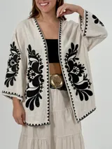 Kimono color crema de lino italiano con bordados florales negros en mangas y frente.