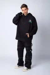 Buzo canguro negro de algodón friza, corte oversize y estampa de Mickey Mouse con detalles en verde.