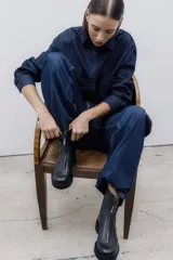 Bota corta de cuero color chocolate, con cierre central y suela de goma.