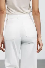 Pantalón de jean celeste de tiro alto y corte wide leg, con bolsillos frontales y traseros, cierre frontal con cremallera y botón metálico.