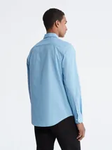 Camisa celeste de vestir Calvin Klein, de corte entallado, manga larga y cuello clásico.