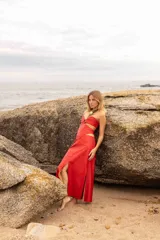 Vestido largo color rojo, con escote strapless, aberturas en la cintura y falda con tajo lateral.