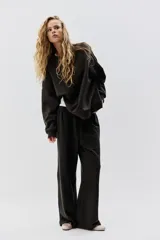 Buzo de tejido liso, color negro, con cuello redondo, hombros caídos y puños y bajo acanalados.