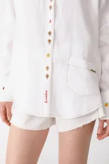 Camisa blanca de lino con botones de carey con forma de frutas, manga larga y bolsillo de parche en el pecho.