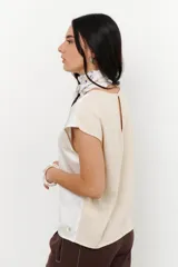 Blusa de manga 3/4 y cuello redondo, confeccionada en lino con acabado metalizado en tono beige o dorado claro.