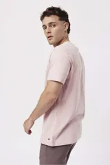 Remera de algodón color naranja claro con cuello redondo y manga corta. Presenta un pequeño estampado gráfico de temática playera en el pecho izquierdo.