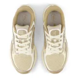 Championes New Balance Arishi V4, color beige con detalles en blanco y amarillo, ideales para running.