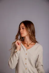 Blusa de morley elastizado color beige, de calce ajustado y mangas largas.