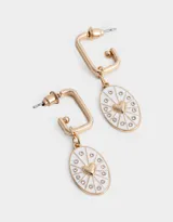 Aros argolla dorados esmaltados en blanco, con dije ovalado con corazón dorado y strass.