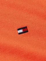 Chomba naranja de Tommy Hilfiger, corte regular, con cuello tipo chomba, cartera de dos botones, logo bordado en el pecho y mangas cortas.