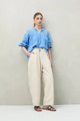 Blusa blanca de algodón con encaje floral en la parte superior, mangas largas abullonadas y escote con lazo.