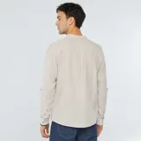 Camisa de lino color beige, de manga larga y cuello mao.