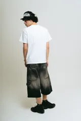 Bermuda de jean negro lavado, corte baggy carpintero, con bordado gótico en la parte trasera, bolsillos grandes, bolsillo lateral y tira carpintera lateral.