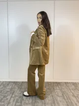 Conjunto de saco y pantalón de pana color marrón claro. El saco es de corte clásico con solapas y bolsillos delanteros. El pantalón es de corte recto y tiro alto.