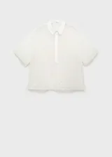 Camisa blanca semitransparente con bordado de flores, cuello camisero, manga corta y cierre frontal con botones.